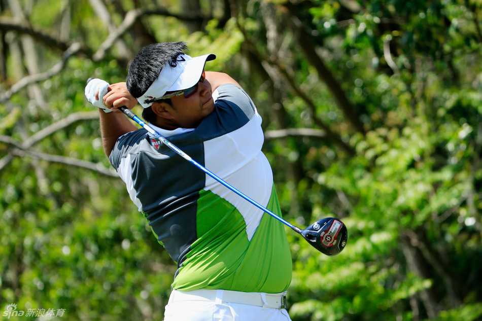 扎克·约翰逊与他的球童并肩站在果岭上，两人目光聚焦同一点，正进行着最后击球前的关键决策交流