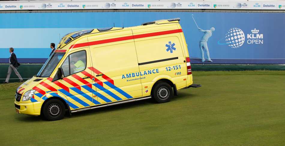 救护车稳稳停在球场通道，医护人员准备转运，标志着紧急情况得到有效控制。