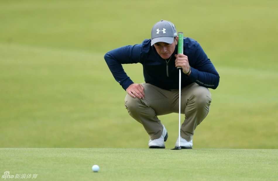 保罗·邓恩俯身凝视球道，眼神如鹰隼般锐利，仿佛在与草地无声对话。