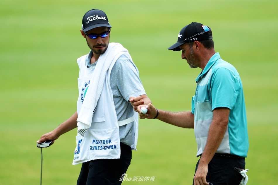 球手在沙坑中救球，沙粒飞溅，展现了高尔夫比赛中处理困难球位的技巧与力量。