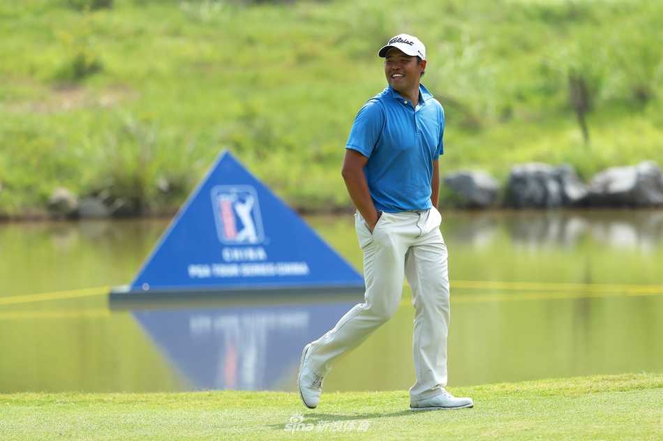 球员在清澈的水障碍旁谨慎选杆，水面倒映着山峦与天空，宁静中充满挑战。