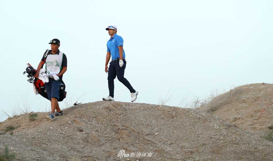 球员在强风中凝视空中小球，衣袂被吹得猎猎作响，帽檐压低以抵御风沙，专注判断风对弹道的影响。