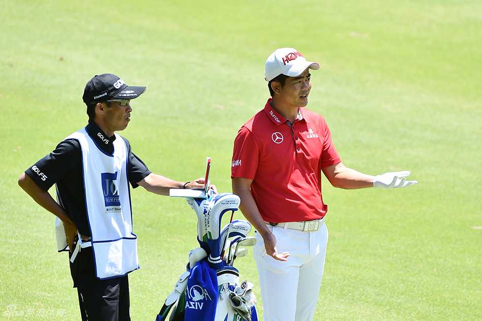 梁文冲与球童在球道上并肩前行，两人神情专注地审视前方的落点与地形，仿佛正在无声地交流战术。