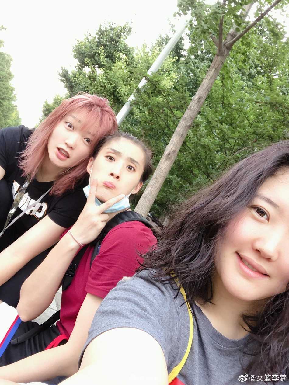 李梦与好友亲密依偎，她新染的发色在阳光下泛着温柔的光泽，两人脸上洋溢着真挚的友情