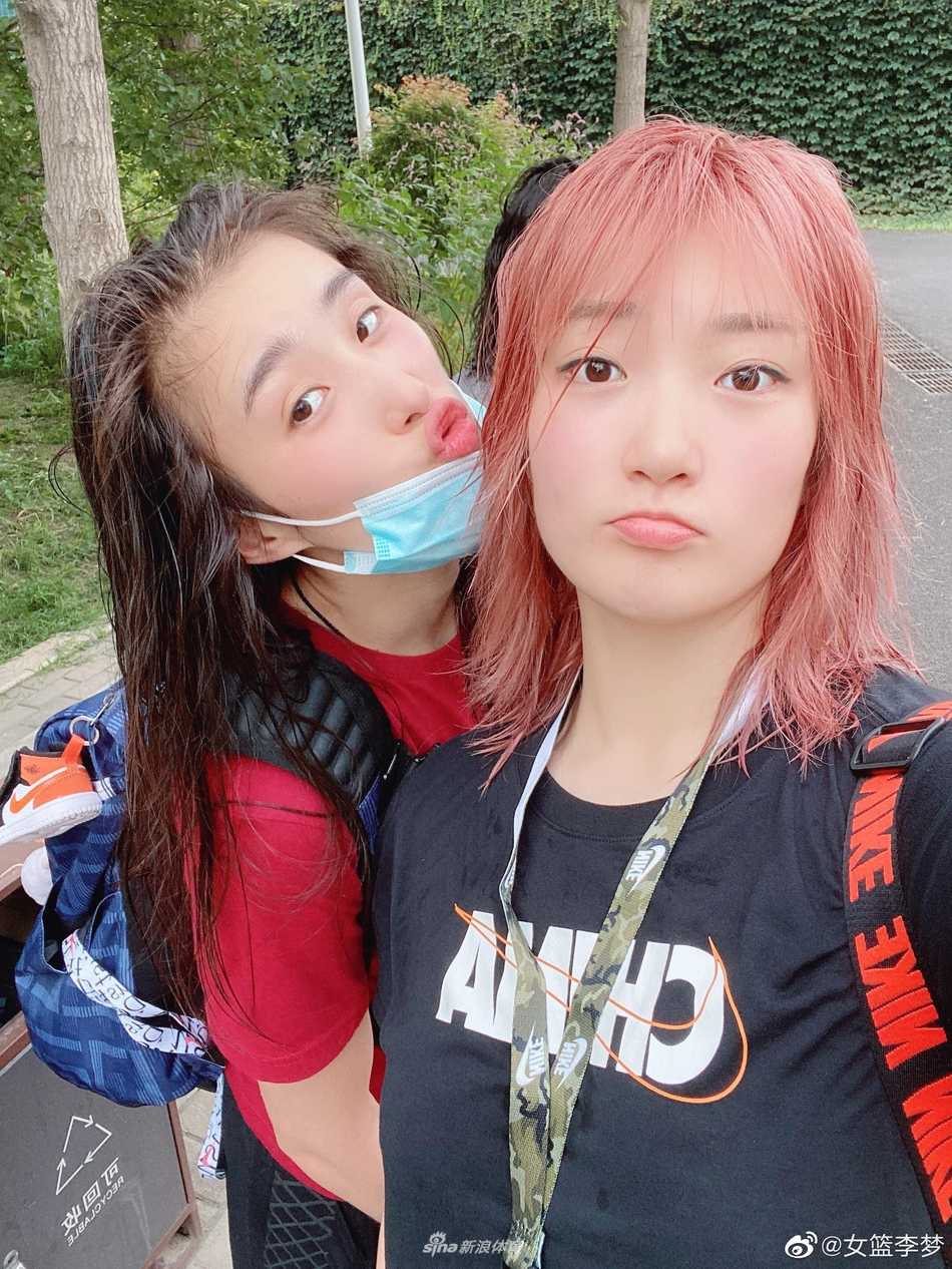 李梦与好友头靠着头，在柔和的灯光下，新发色显得格外迷人，定格了属于她们的温馨瞬间