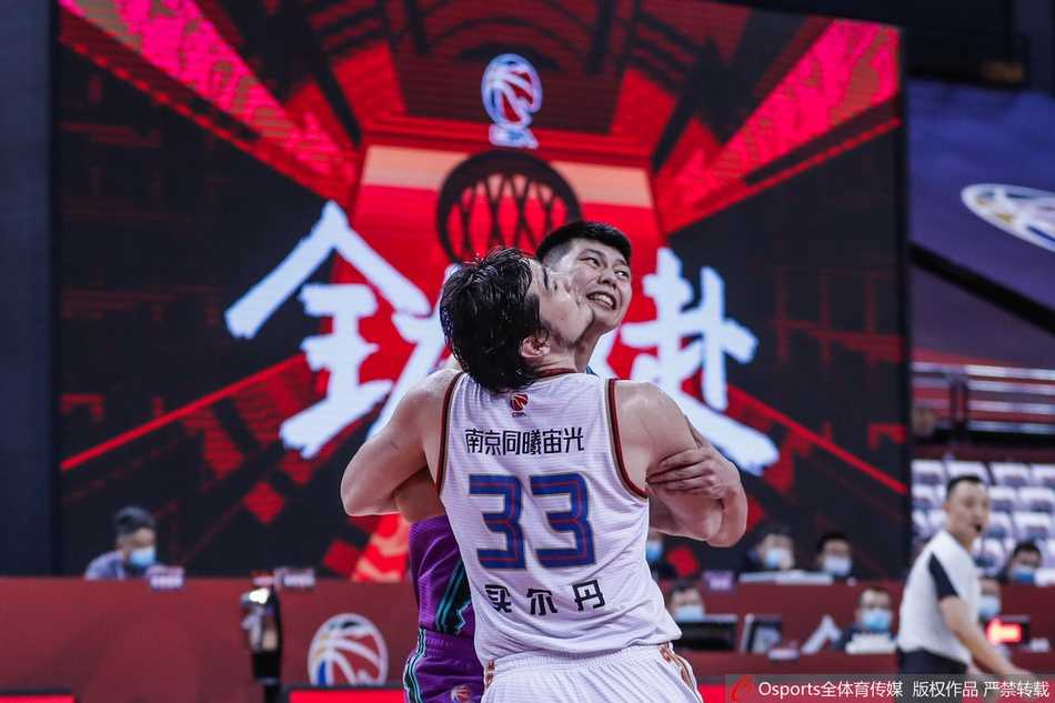 北京队球员跳起传球，皮球在空中划出一道弧线，队友早已在篮下就位准备完成致命一击