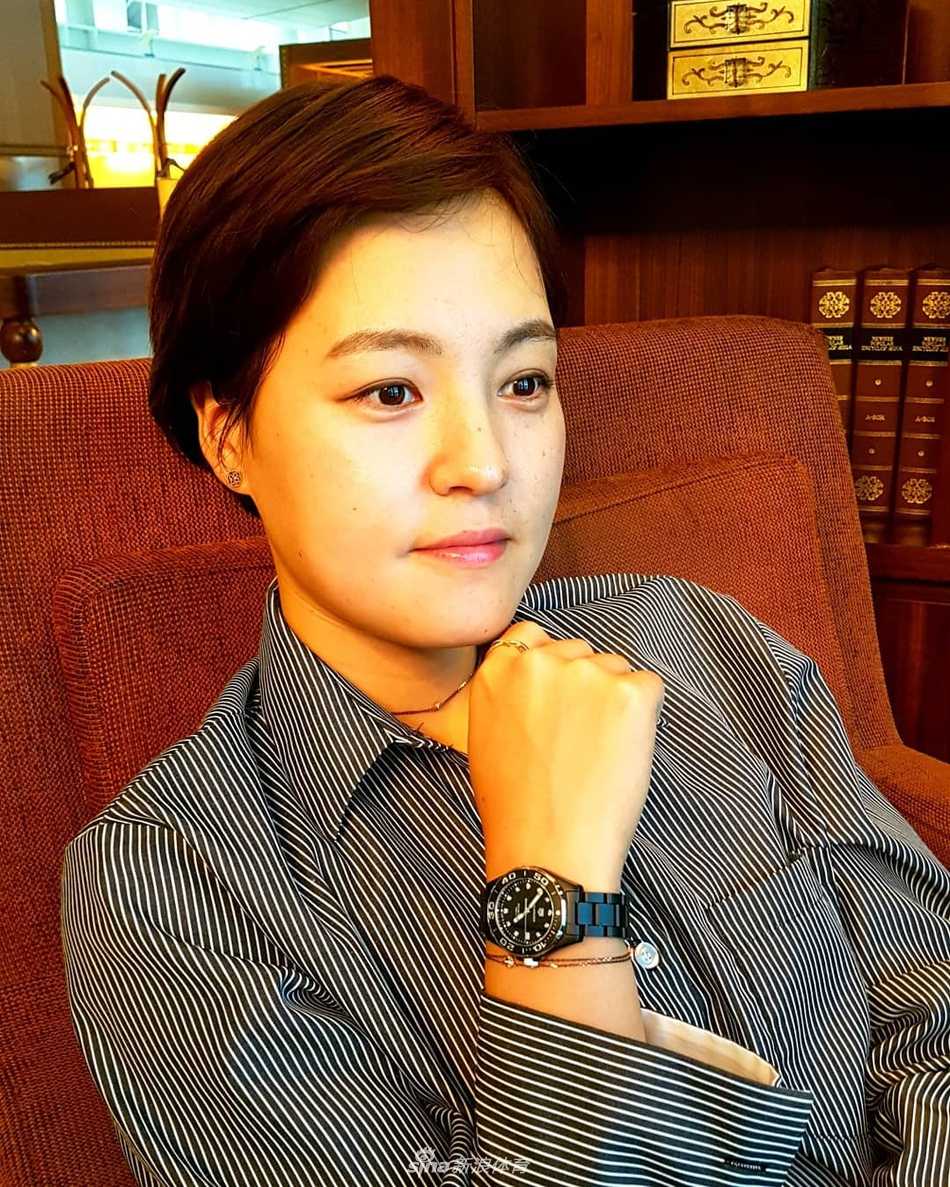 她低头整理手套，短发自然垂落，侧脸线条在光影中显得坚定而柔和