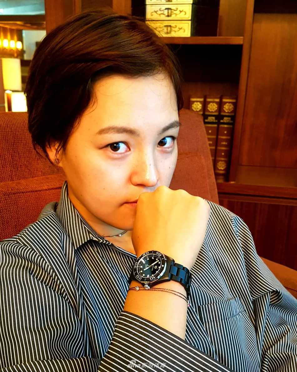 田仁智漫步于球场草甸，短发被风吹起，步履间尽显洒脱随性之美