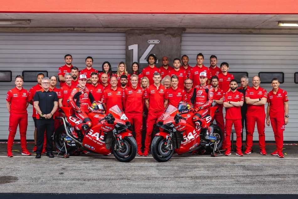 红白相间的赛车如一道闪电，在湛蓝天空与灰黑赛道的宏大背景下，留下一条预示速度与方向的动态残影。