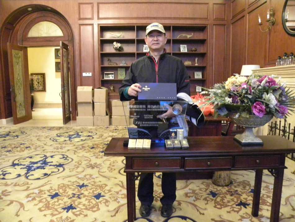 高尔夫球手在果岭上专注推杆，背景是广阔的球场和远山