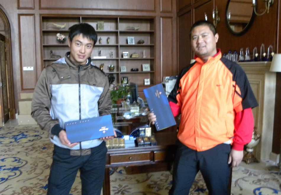 高尔夫球童站在球车旁，手拿记分卡，正在协助球员确认成绩