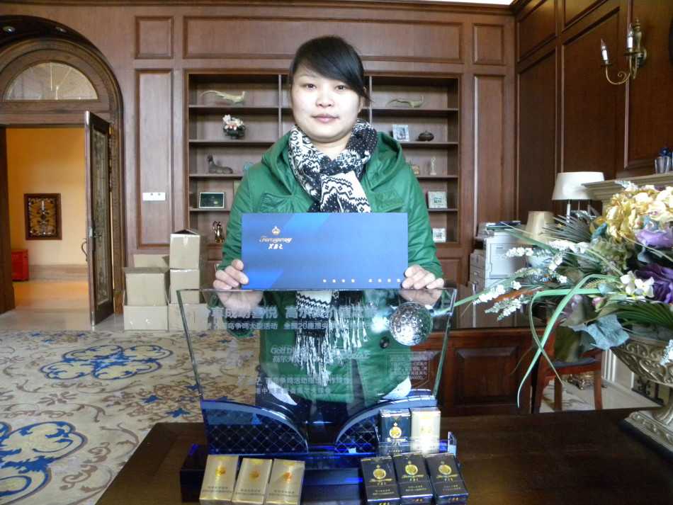 两位球手在会所前台展示获得的芙蓉王礼盒，面带喜悦笑容