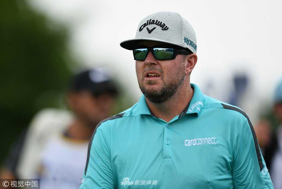 盖瑞古斯雨中闪耀阿比幽谷领先群雄,约翰逊后来居上终捧杯 首轮比赛因雷雨警报暂停,工作人员覆盖果岭,背景天空乌云密布