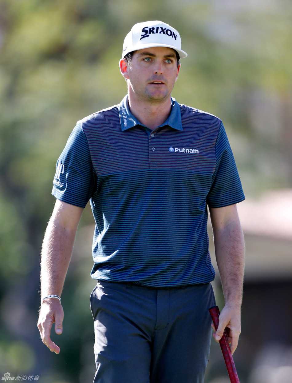 基根·布拉德利蹲在果岭上，单手扶地，全神贯注地审视着小白球与洞杯之间微妙的起伏线路