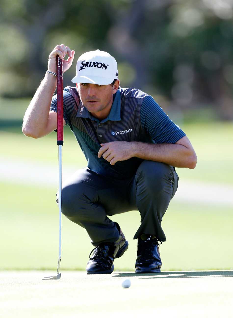 菲尔·米克尔森在沙坑中屈膝蓄力，目光锐利地锁定小球，正准备挥出他那标志性的神奇救杆