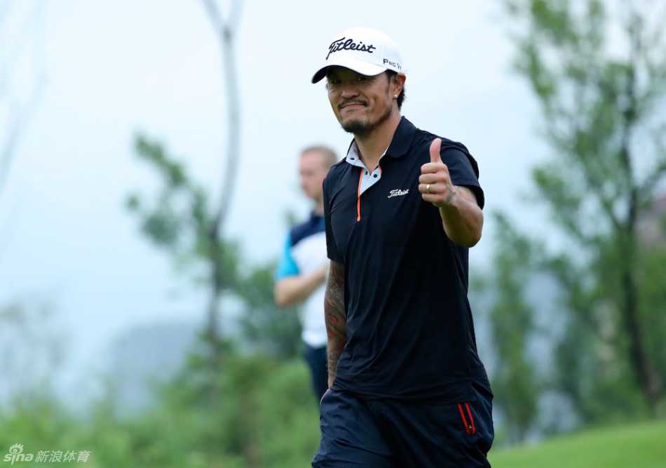 澳大利亚选手大卫-卢特鲁斯在重庆赛场上，于三杆洞果岭旁弯腰，正从球洞中取出实现一杆进洞的小球，面露惊喜