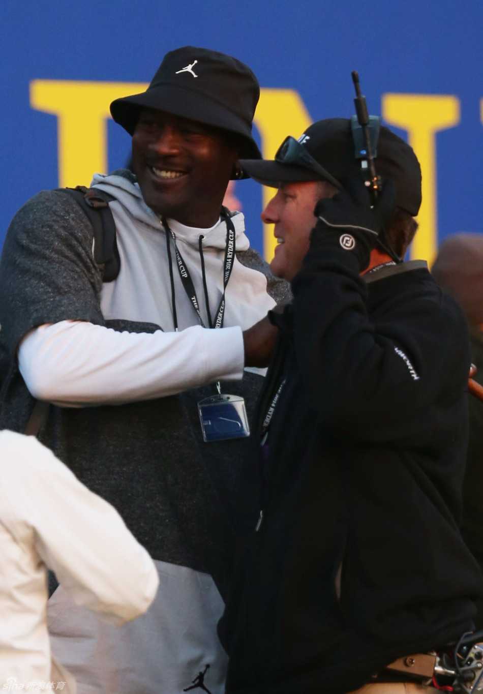 乔丹侧身与友人交谈，手指向赛场方向，似乎在分析刚结束的一记关键击球。