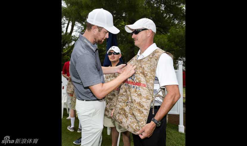 老虎伍兹神情专注，正在一面巨大的签名墙上留下自己的名字。