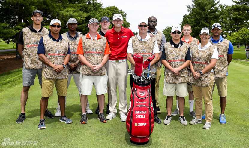 高球名将里奇·福勒在果岭旁俯身，耐心指导一位年轻的小球迷挥杆技巧。