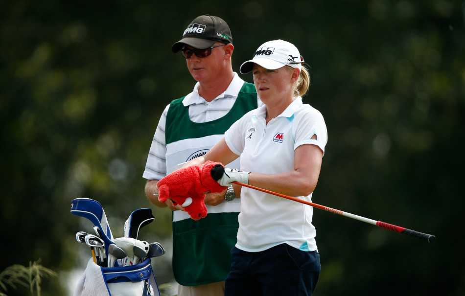 绿茵争锋:女将挥杆展英姿 果岭对决显风华 史黛西·刘易斯在研究攻略,她手持球杆凝视远方球道,正在为接下来的挑战进行周密思考。