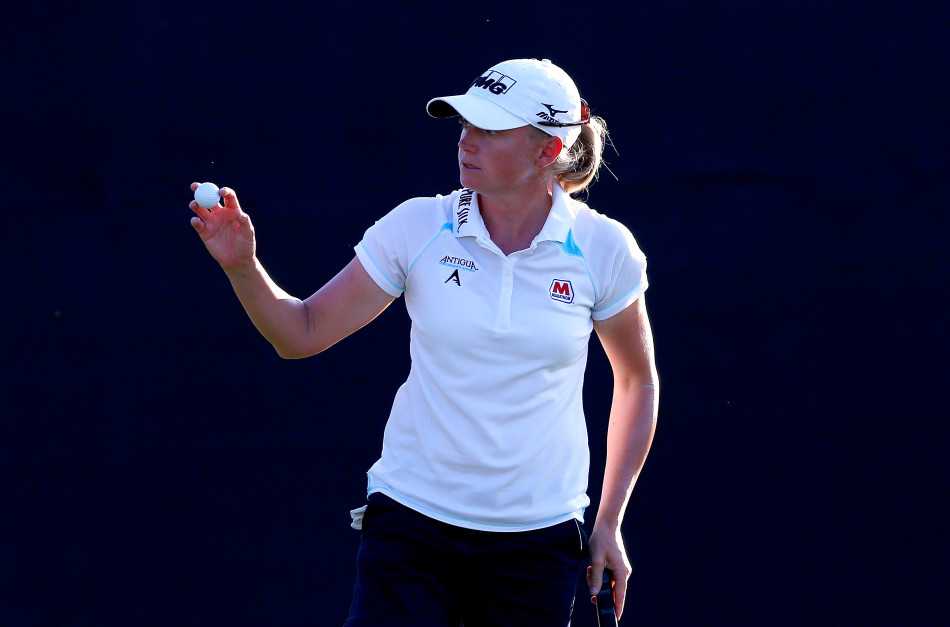 绿茵争锋:女将挥杆展英姿 果岭对决显风华 许美贞在果岭上进行关键推杆,全场目光聚焦于此,气氛紧张而静谧。